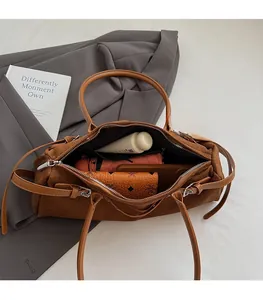 Detailed interior of a brown suede shoulder bag showing spacious storage capacity