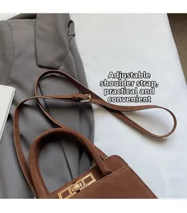 Detail of adjustable strap and golden turn-lock on dark brown vintage crossbody bag