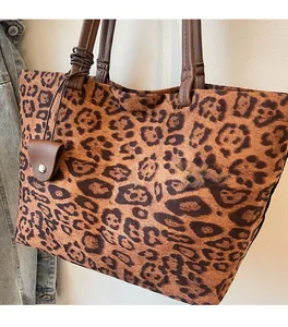 Détail du sac cabas léopard montrant la texture douce et les anses en cuir marron