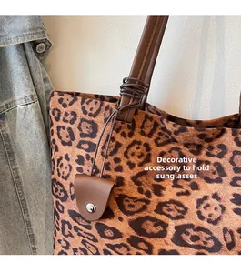 Détail du sac cabas léopard avec anse en cuir et attache pour lunettes de soleil