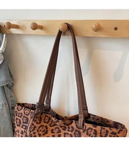 Détail du sac cabas léopard avec bretelles en cuir brun et nœuds de corde