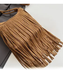 Gros plan du sac en daim marron montrant les détails des franges et la texture mate