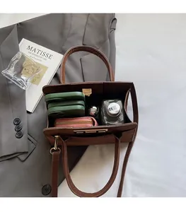 Spacious interior of a dark brown faux leather tote bag with various everyday essentials