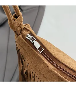 Détail de la fermeture éclair argentée et des longues franges sur le sac en daim