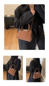 Detail view of brown faux suede square crossbody bag featuring gold metal buckle closure