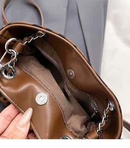 Close-up of leopard print bucket bag featuring a secure silver magnetic snap closure
