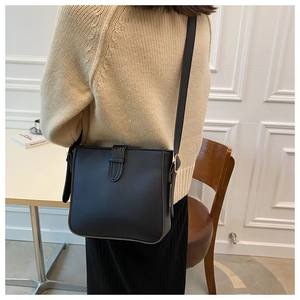 Nahaufnahme der schwarzen Leder-Eimertasche mit Zierschnalle und Schultergurt