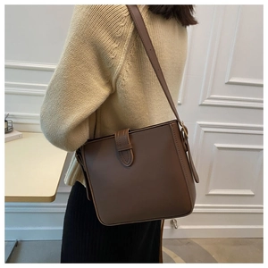 Detail einer braunen Bucket Bag aus Leder aus der Seitenansicht an einem weiblichen Model