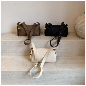 Detailed view of three lychee grain cylinder bags in brown, black, and beige colors