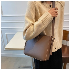 Detailansicht der glatten braunen Ledertasche mit verstellbarem Riemen an einem Model