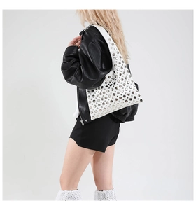 Detail of white studded shoulder bag with silver metal rivets and smooth leather finish