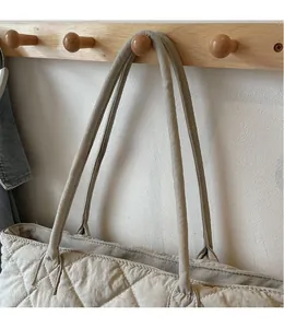 Détail du motif matelassé en losange et des coutures sur un cabas en nylon kaki
