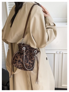 Detail of leopard print bucket bag with drawstring closure and metal chain strap