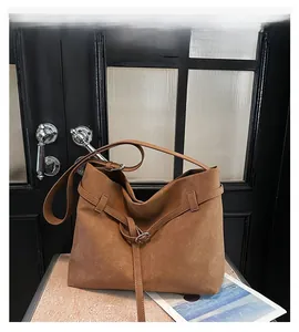 Detail view of large brown suede tote bag with adjustable strap and metallic side buckle