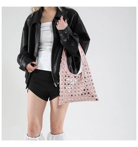 Close-up of pink patent leather handbag with silver stud details and gothic style