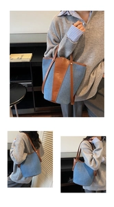 Detail of blue denim bucket bag with brown leather trim and slim shoulder straps