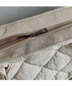 Détail de la fermeture éclair en métal et texture matelassée en losange du grand sac cabas