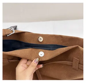Close-up of secure magnetic snap closure on a vintage brown faux suede tote bag