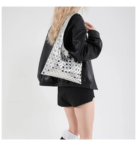 Detail of silver studded shoulder bag with metallic rivets and mirrored finish