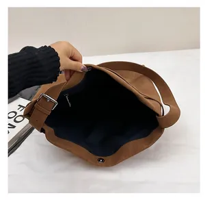 Detail of the large capacity interior with magnetic snap and zipper pocket on suede tote