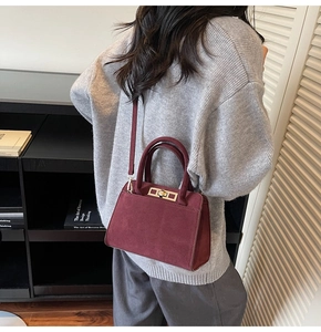 Détail du sac à main bordeaux mat avec boucle en métal doré et poignée supérieure robuste