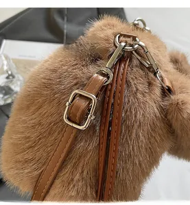 Détail du sac seau en peluche marron montrant la texture douce et les boucles en argent