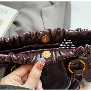 Detailed view of dark burgundy pleated leather bag with secure magnetic closure