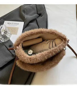 Intérieur spacieux du sac bandoulière en peluche marron avec parapluie et accessoires