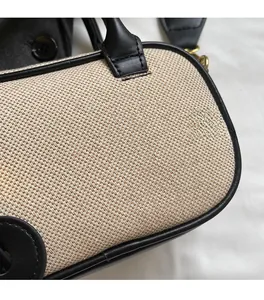 Macro detail van beige geweven canvas handtas met zwarte lederen bies en strak stiksel