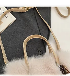 Détail de la bandoulière en cuir et de la texture pelucheuse d'un sac à main d'hiver