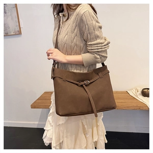 Close-up of brown suede tote bag with stylish buckle strap and premium matte texture