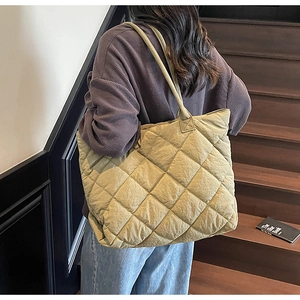 Macro detail of quilted cotton tote bag with olive green stitching and soft texture