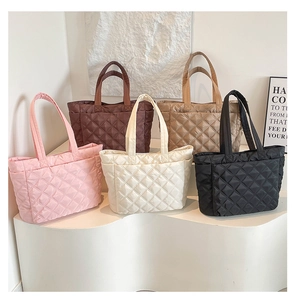 Detailed display of five colorful diamond quilted tote bags in a studio setting
