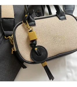 Detail van Boston-tas met beige canvas, zwarte lederen bekleding en decoratieve hanger