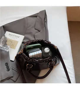 Detail view of the spacious inner compartment of this brown pleated leather handbag