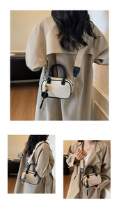 Detail van vintage tweekleurige mini-tas met leren bies en kwastje aan de brede riem