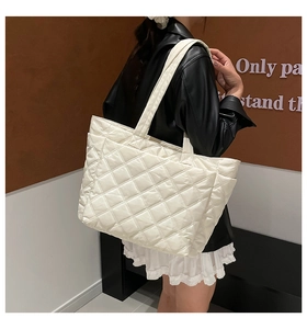 Detail of white quilted nylon tote bag with rhombus pattern and wide shoulder strap