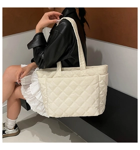 Quilted diamond lattice tote bag in cream white shown on a model for daily use