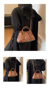 Detail of vintage brown pleated dumpling bag with golden rings and detachable strap