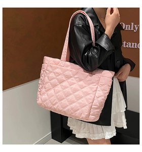 Pink quilted nylon tote bag worn by a model to show its large capacity and stylish fit