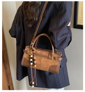 Dettaglio ravvicinato della borsa Boston retrò con patchwork in pelle scamosciata e nappa