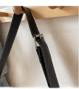 Close-up of adjustable black leather strap with white stitching and silver buckle