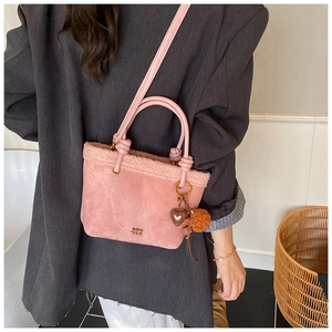 Borsa a secchiello in camoscio rosa con bordo in pelliccia, ciondolo a cuore e tracolla