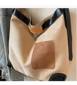 Macro detail of beige suede tote bag with black trim and brown outer pocket texture
