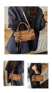 Close-up of brown suede patchwork baguette bag with decorative beaded tassel and strap