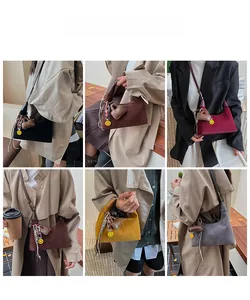 Detail showing faux suede crescent bucket bags with charm accessories in five colors