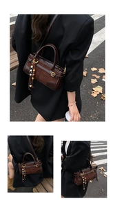 Detail of dark brown leather Boston bag with retro tassel and adjustable strap