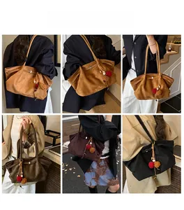 Gros plan de grands sacs cabas en daim avec plis latéraux et charms pompons contrastés