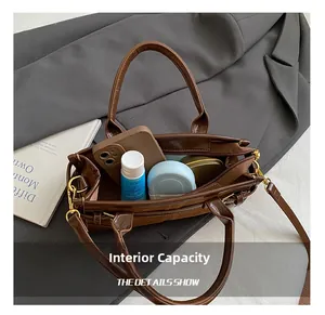Detail view of large capacity interior showing phone and cosmetics in dark brown bag
