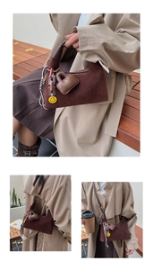 Detail showing dark brown suede crescent bag with heart charm and woven rope texture
